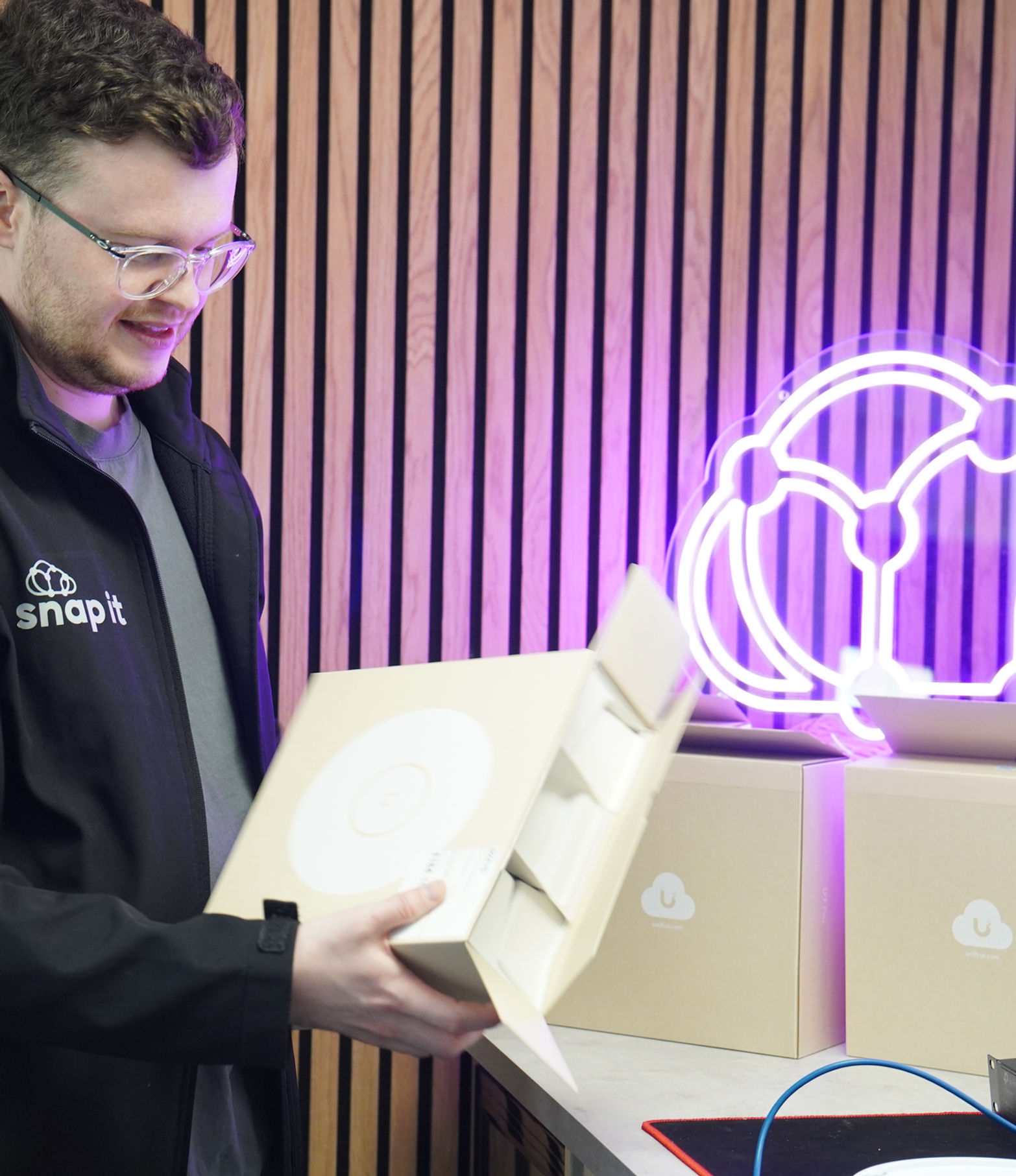 Snap IT engineer unboxing a UniFi wireless access point